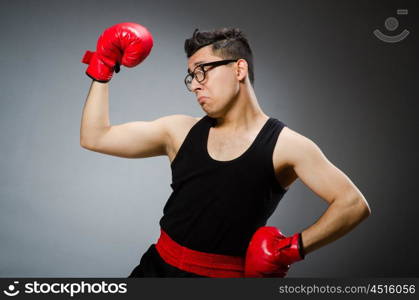 Funny boxer with red gloves against dark background