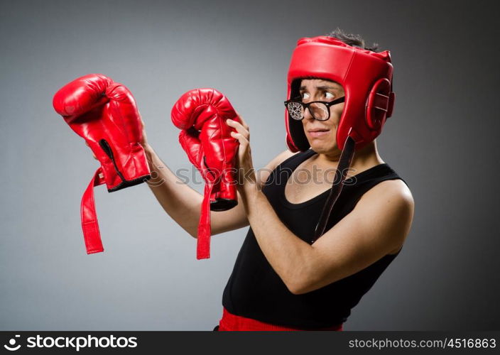 Funny boxer with red gloves against dark background