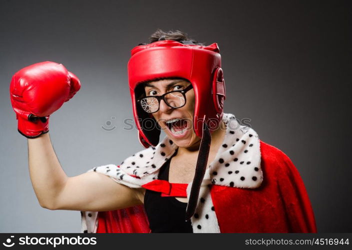 Funny boxer with red gloves against dark background