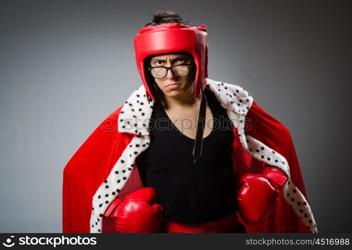 Funny boxer with red gloves against dark background