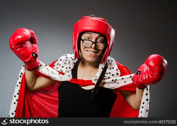 Funny boxer with red gloves against dark background