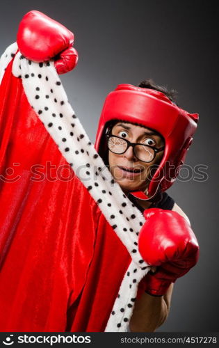 Funny boxer with red gloves against dark background