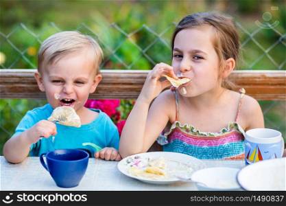 Funny boy and girl eating dumplings and making a mess. Funny boy and girl eating