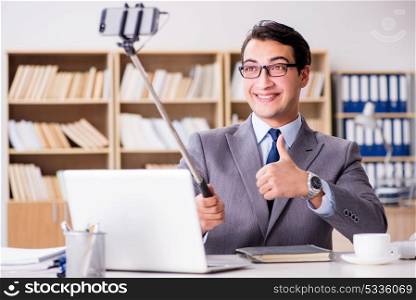 Funny businessman taking selfie in office