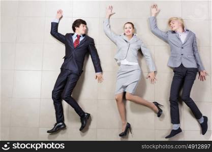 Funny businesspeople. Young people in business suits lying on floor