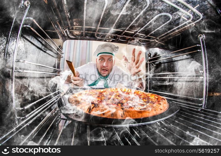 Funny chef overlooked pizza in the oven, so she had scorched, view from the inside of the oven. Cook perplexed and angry. Loser is destiny!