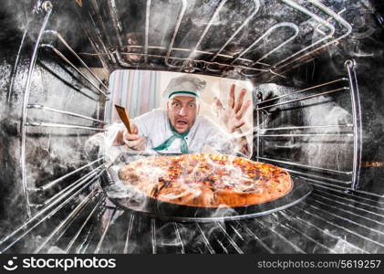 Funny chef overlooked pizza in the oven, so she had scorched, view from the inside of the oven. Cook perplexed and angry. Loser is destiny!