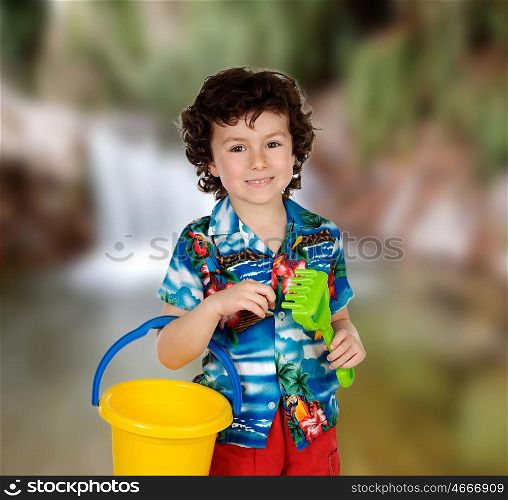 Funny child in holidays with a bucket and shovel to play with sand
