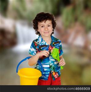 Funny child in holidays with a bucket and shovel to play with sand