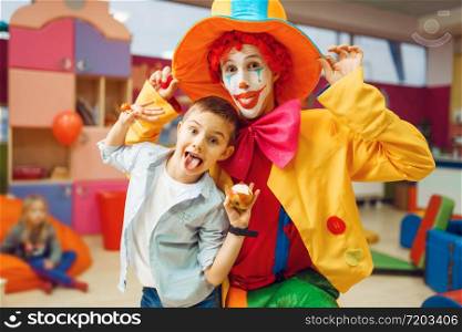 Funny clown, entertainment show with little boys in kindergarten. Birthday celebrating in playroom, baby holiday in playground. Childhood happiness, childish leisure. Funny clown, entertainment show with little boys