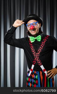 Funny clown in humorous concept against curtain