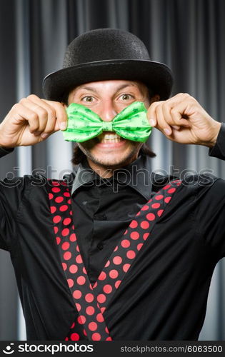 Funny clown in humorous concept against curtain