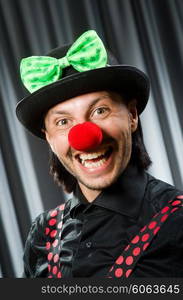 Funny clown in humorous concept against curtain