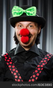 Funny clown in humorous concept against curtain