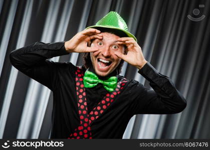 Funny clown in humorous concept against curtain