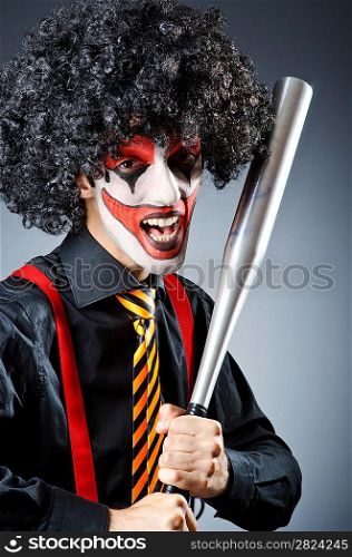 Funny clown with bat in studio