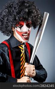 Funny clown with bat in studio