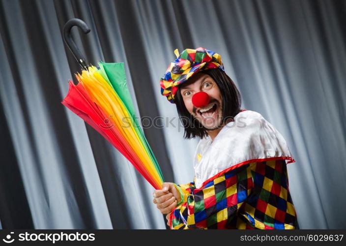 Funny clown with colourful umbrella