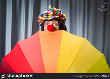 Funny clown with colourful umbrella