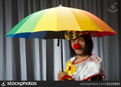 Funny clown with colourful umbrella