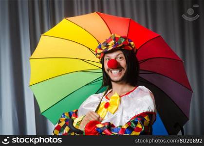 Funny clown with colourful umbrella