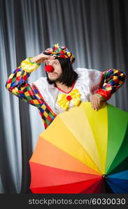 Funny clown with colourful umbrella