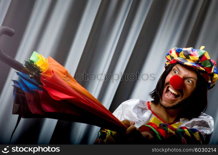 Funny clown with colourful umbrella