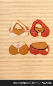 Funny colorfull bikini shape gingerbread cakes cookies sweet dessert with icing and decoration on beige bamboo mat