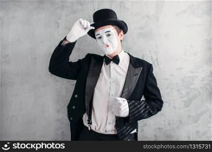 Funny comedy actor with makeup face. Pantomime in suit, gloves and hat. April fools day concept