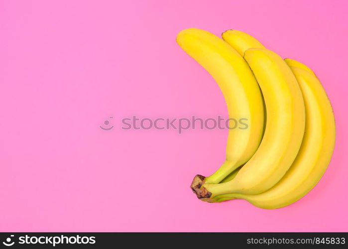 Funny concept image - bunch of bananas isolated on a pink background in top view (copy space)