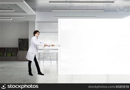 Funny doctor with billboard. Young male funny doctor showing white blank banner