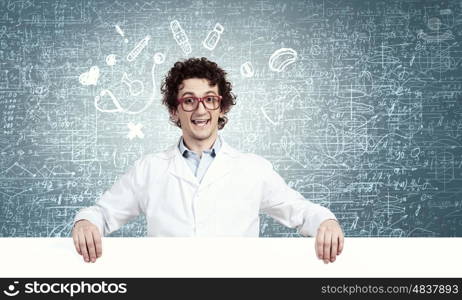 Funny doctor with billboard. Young male funny doctor showing white blank banner