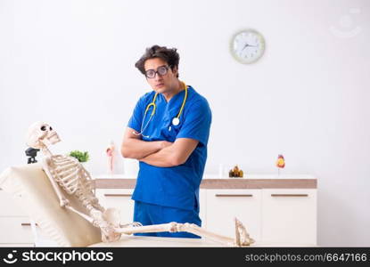 Funny doctor with skeleton in hospital