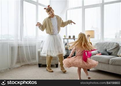 Funny dressed tired father dancing with cute little daughter at home living room. Funny dressed father dancing with cute little daughter