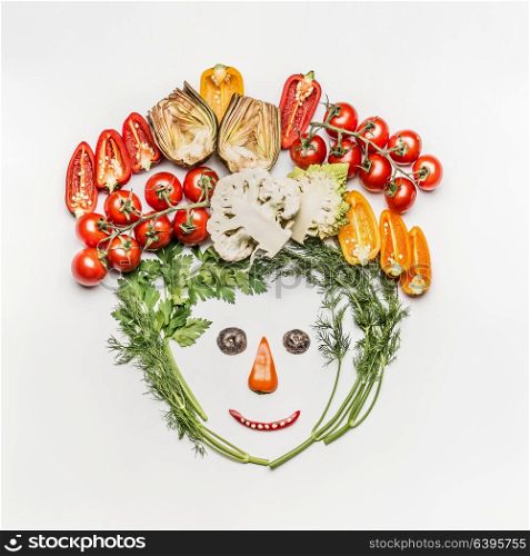 Funny face made of various fresh vegetables on white background, top view. Healthy clean eating, dieting meal or vegetarian food concept