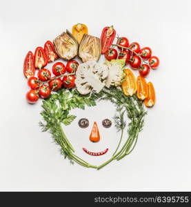 Funny face made of various fresh vegetables on white background, top view. Healthy clean eating, dieting meal or vegetarian food concept