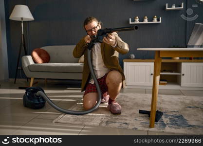 Funny freelance businessman having fun with vacuum doing household chores and working online. Office hunter. Funny businessman having fun during working online