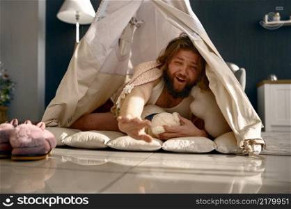 Funny freelance businessman with sleepy face awake in teepee tent. Morning at home office. Funny freelance businessman awake in teepee tent