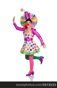 Funny girl clown with a big colorful wig dancing isolated on white background