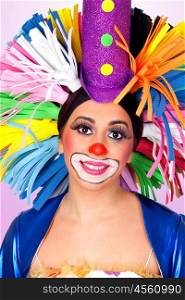 Funny girl clown with a big colorful wig isolated on orange background