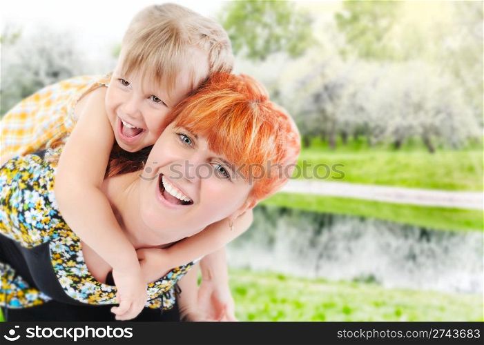 Funny girl hugs her young mother in the park
