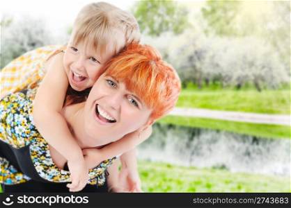 Funny girl hugs her young mother in the park