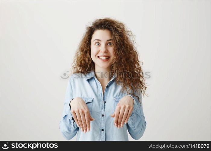 Funny girl showing bunny hands with her hands isolated on gray background.. Funny girl showing bunny hands with her hands isolated on gray background