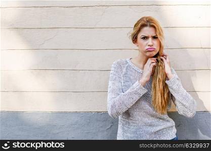 Funny girl with the face of protest. Woman snorting in urban background