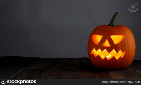 Funny glowing Halloween Jack O&rsquo; Lantern Pumpkin on gray background. Jack O&rsquo; Lantern Halloween pumpkin