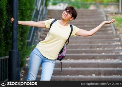 Funny happy middle-aged woman wearing eyeglasses in an urban park.. Funny happy middle-aged woman in an urban park.