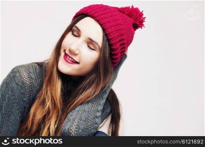 Funny hipster girl in knitted grey sweater and beanie marsala hat. Bright lips, having fun. Trendy casual fashion outfit in winter.