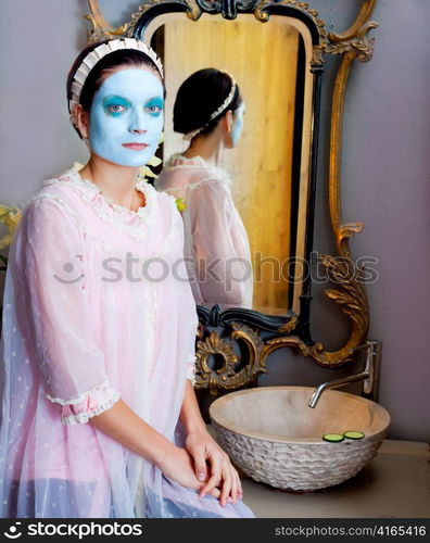 Funny housewife beauty treatment green clay mask at the mirror