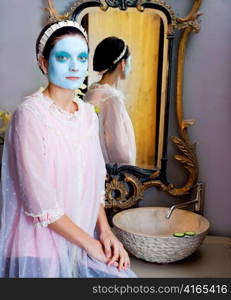 Funny housewife beauty treatment green clay mask at the mirror