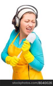 funny housewife holding a brush instead of a microphone isolated